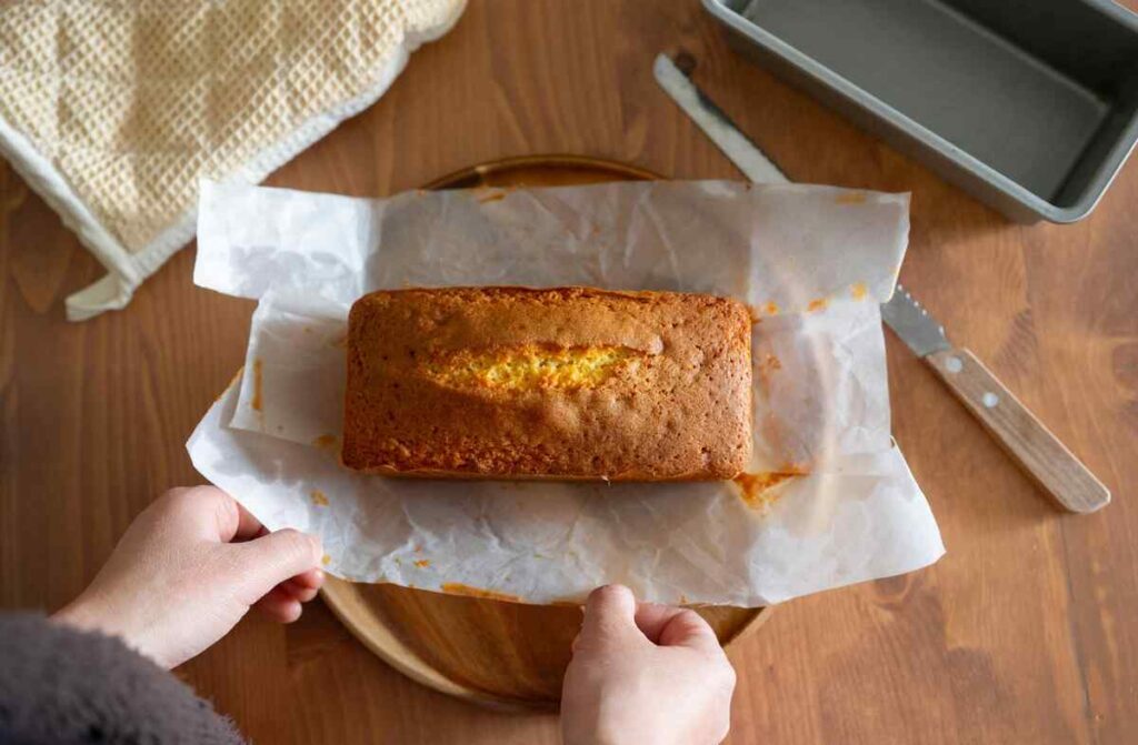 Versgebakken citroencake op bakpapier op een houten tafel.